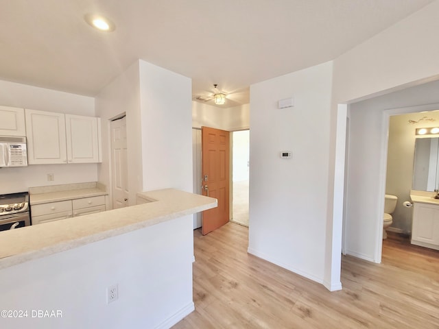 kitchen featuring electric stove, white cabinets, and light hardwood / wood-style flooring