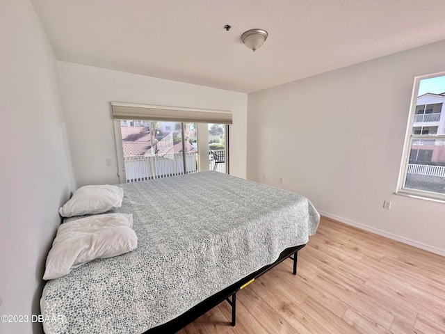 bedroom featuring access to exterior and light hardwood / wood-style flooring