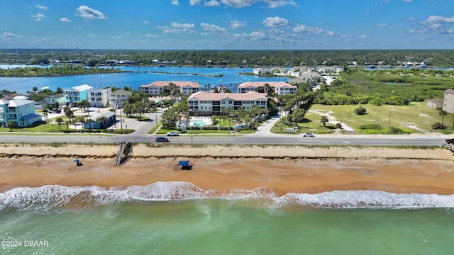 drone / aerial view featuring a water view and a view of the beach