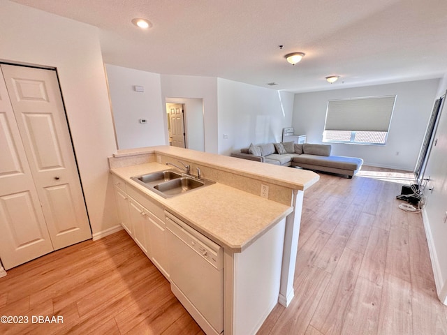 kitchen featuring white dishwasher, kitchen peninsula, sink, and light hardwood / wood-style flooring