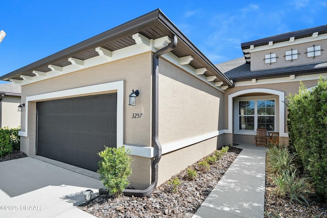 property entrance with an attached garage and stucco siding