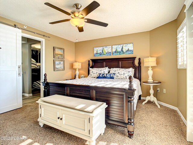 bedroom featuring a textured ceiling, light carpet, and ceiling fan