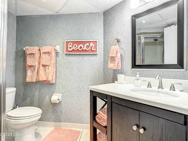 bathroom featuring tile patterned flooring, a paneled ceiling, toilet, and vanity