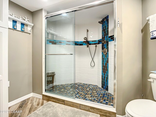 bathroom featuring hardwood / wood-style floors, toilet, and an enclosed shower