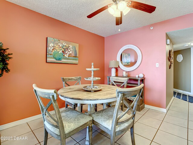 tiled dining room featuring a textured ceiling and ceiling fan