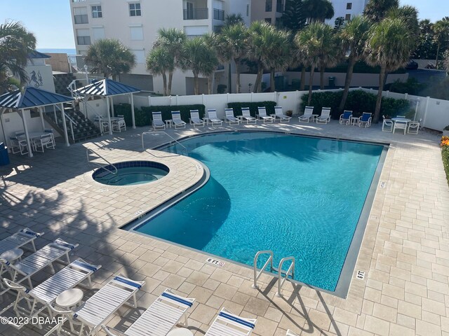 view of pool with a community hot tub, a gazebo, and a patio area