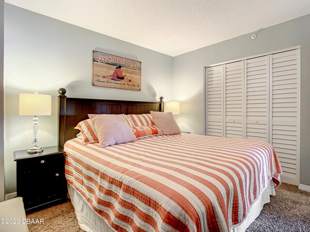 bedroom with light colored carpet and a textured ceiling