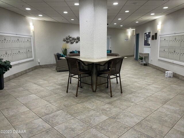 dining area featuring a paneled ceiling and light tile patterned floors