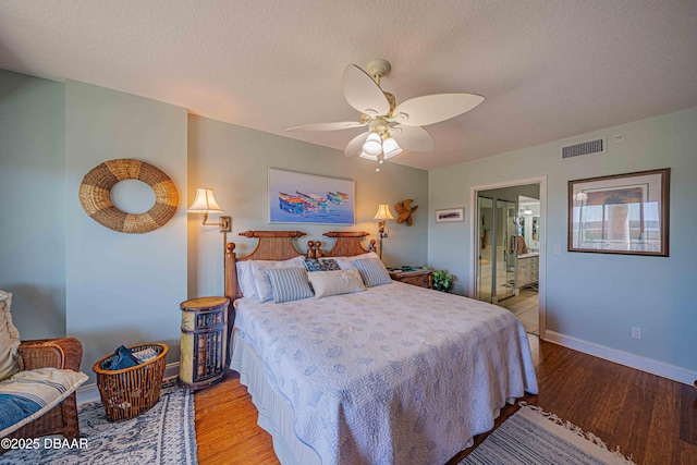 bedroom with light wood-type flooring, baseboards, visible vents, and a textured ceiling