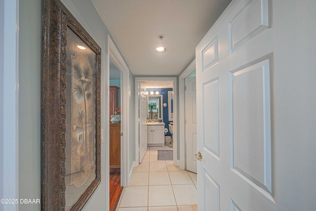 corridor with light tile patterned floors and a textured ceiling