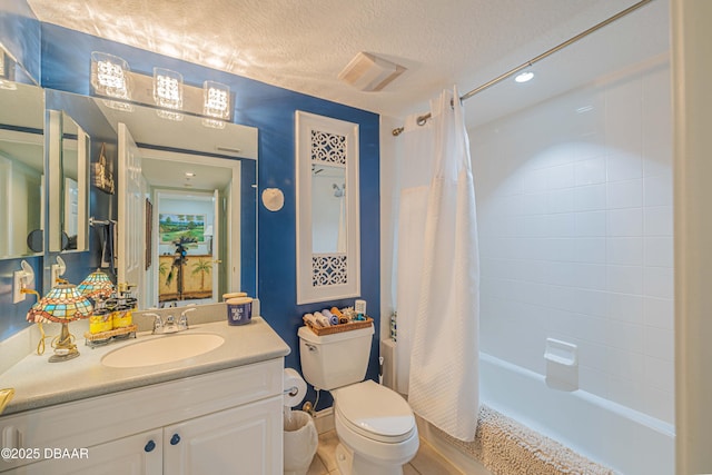 bathroom featuring shower / tub combo with curtain, a textured ceiling, toilet, and vanity