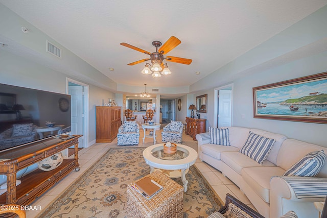 living room featuring ceiling fan with notable chandelier, visible vents, and light tile patterned flooring