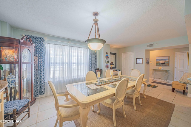 dining room with visible vents, a textured ceiling, and light tile patterned flooring