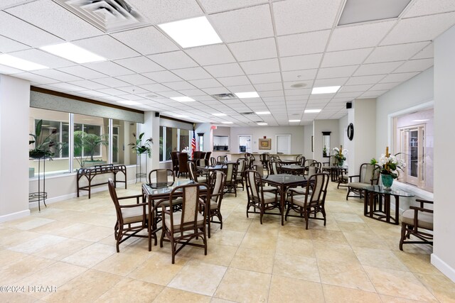 tiled dining area with a drop ceiling