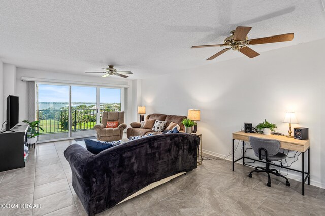 living room featuring a textured ceiling and ceiling fan