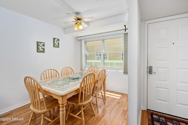 dining room with ceiling fan, a textured ceiling, and light hardwood / wood-style flooring