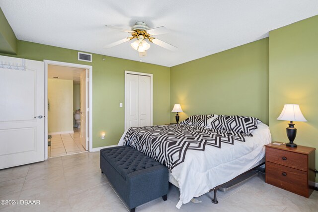 bedroom with a closet, light tile patterned floors, and ceiling fan