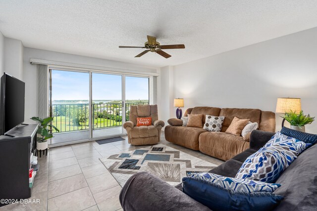 living room with light tile patterned flooring, a textured ceiling, and ceiling fan