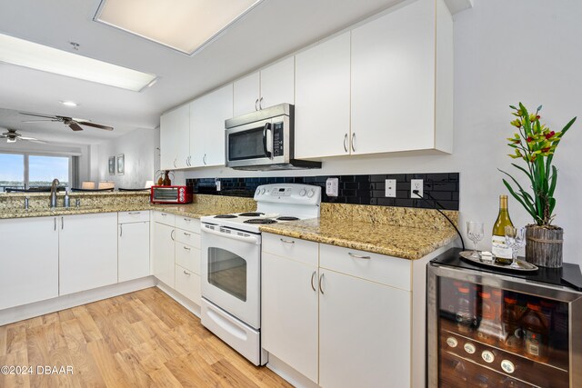 kitchen with white electric range oven, light hardwood / wood-style floors, white cabinetry, and wine cooler