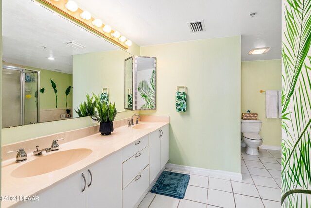 bathroom featuring toilet, vanity, tile patterned floors, and walk in shower