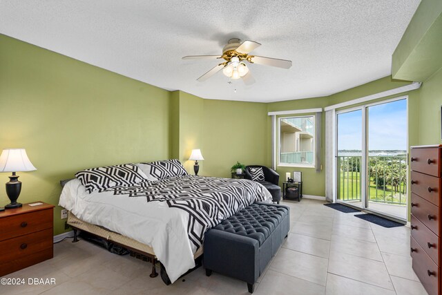 bedroom featuring access to outside, a textured ceiling, light tile patterned floors, and ceiling fan