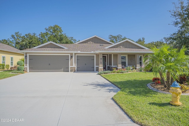 view of front of home with a front yard, covered porch, and a garage