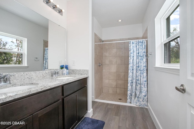 bathroom featuring a shower with curtain, hardwood / wood-style flooring, and a healthy amount of sunlight