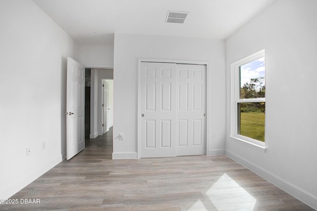 unfurnished bedroom featuring a closet and light wood-type flooring