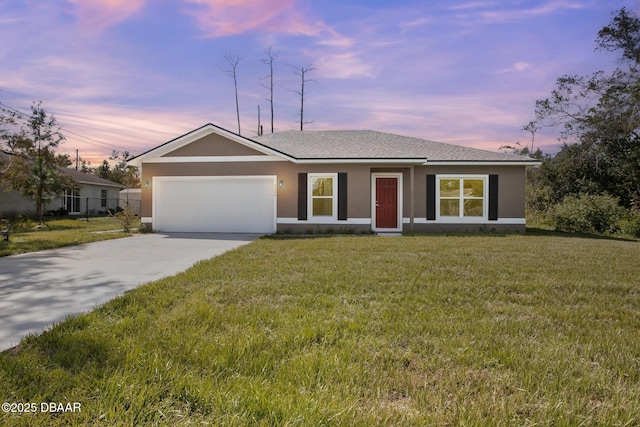 single story home featuring a garage and a lawn