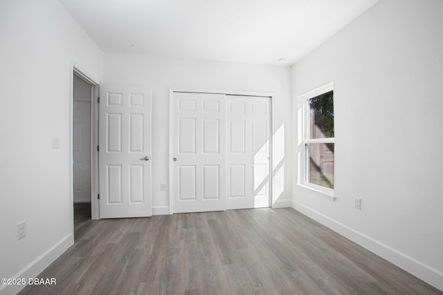 unfurnished bedroom featuring wood-type flooring and a closet