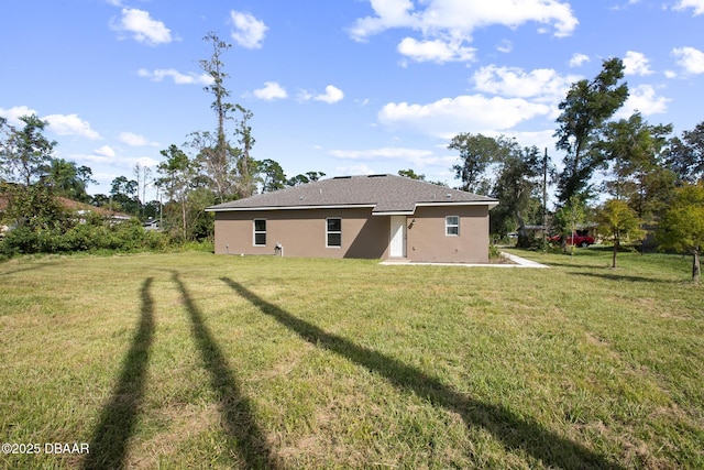 rear view of house featuring a lawn