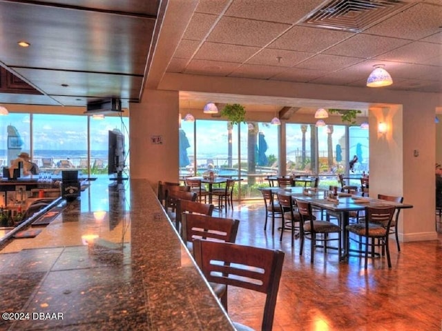 dining room featuring a healthy amount of sunlight and a paneled ceiling