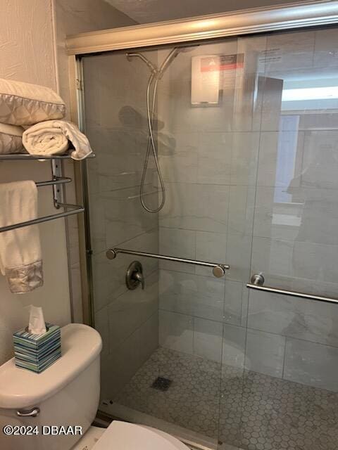 bathroom featuring walk in shower and toilet