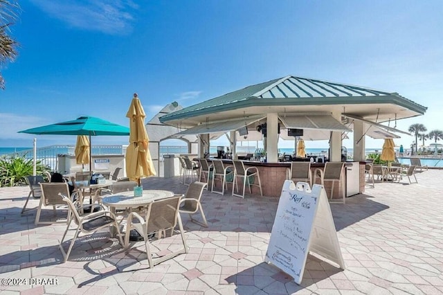 view of patio featuring an outdoor bar and a water view