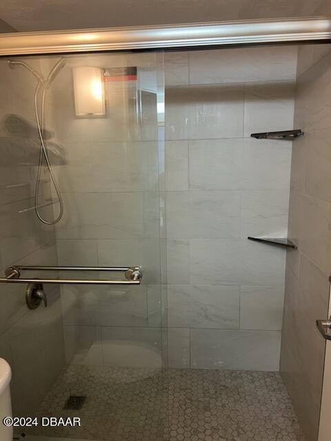 bathroom with toilet and an enclosed shower