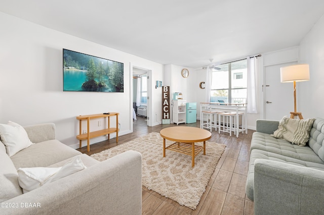 living room with ceiling fan, wood finished floors, and baseboards