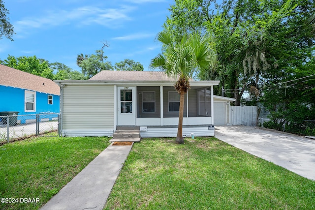 view of front of property featuring a sunroom and a front lawn