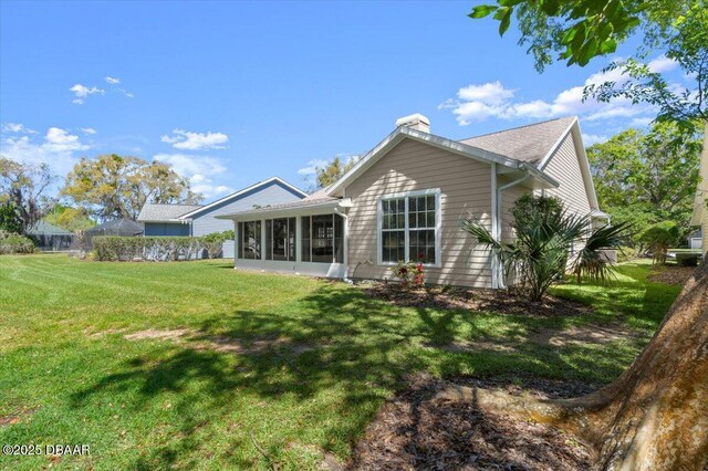 3356 Newbliss Cir, Ormond Beach, FL 32174 - back of house with a lawn, a chimney, and a sunroom