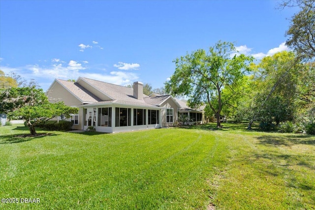 3356 Newbliss Cir, Ormond Beach, FL 32174 - rear view of property with a yard, a sunroom, and a chimney