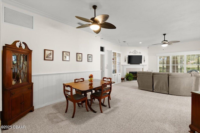 3356 Newbliss Cir, Ormond Beach, FL 32174 - carpeted dining space featuring visible vents, built in shelves, ceiling fan, and a tile fireplace