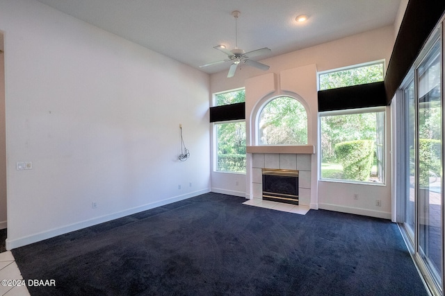 unfurnished living room with carpet flooring, a tile fireplace, and ceiling fan