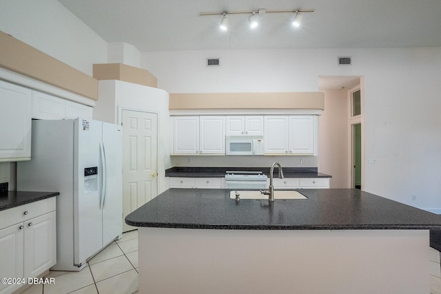 kitchen featuring white cabinetry, light tile patterned floors, sink, white appliances, and a kitchen island with sink