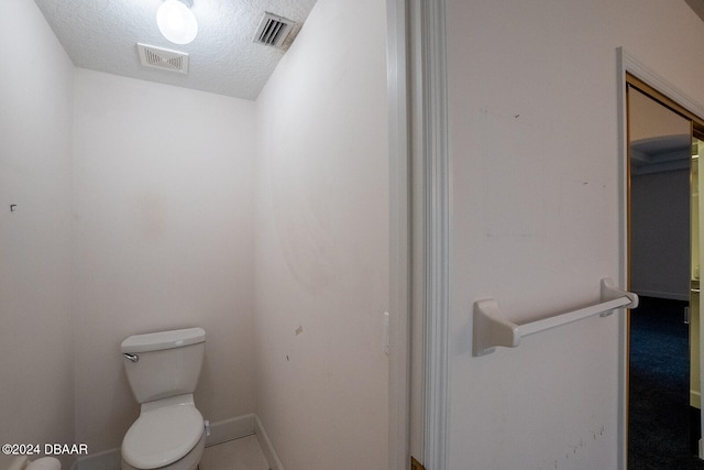 bathroom featuring toilet and a textured ceiling