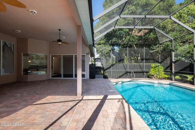 view of pool featuring glass enclosure, ceiling fan, and a patio