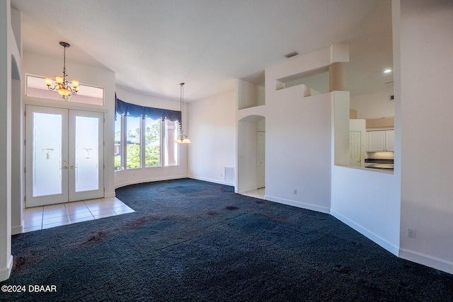 unfurnished living room with french doors, light colored carpet, and a chandelier