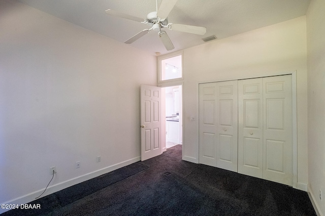 unfurnished bedroom with a closet, ceiling fan, and dark carpet