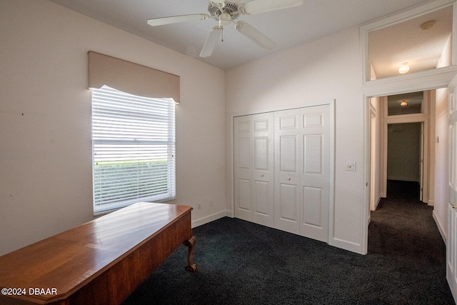 bedroom featuring a closet, dark colored carpet, and ceiling fan