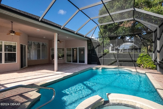 view of pool featuring glass enclosure, ceiling fan, a patio, and an in ground hot tub