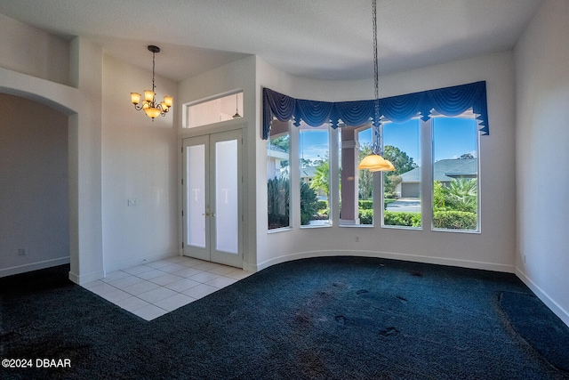 unfurnished dining area featuring a chandelier, a textured ceiling, and carpet floors