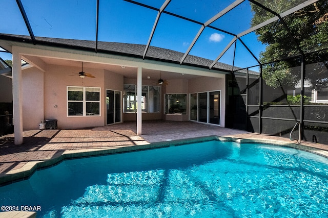 view of swimming pool with glass enclosure, a patio area, and ceiling fan